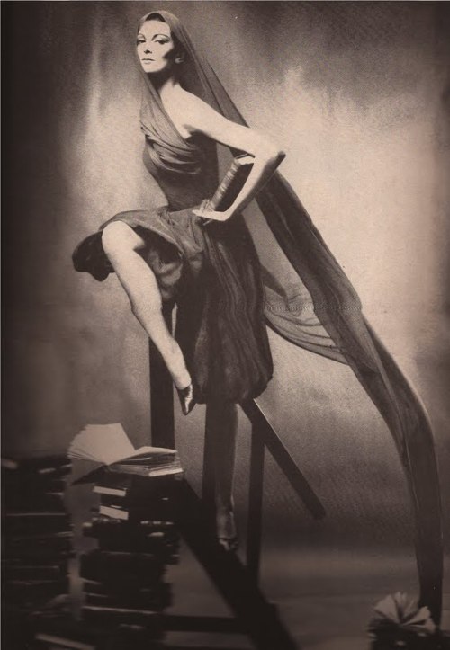 Carmen Dell'Orifice with book and stacks below wearing Norman Norell in Ways to Enjoy the Evening fo