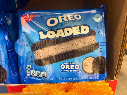 a photo of an oreo package which is labeled "oreos loaded - with real cookie crumbs." the picture shows an oreo with an oreo/cookies and cream filling