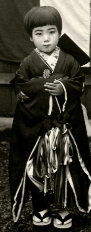 “This postcard shows a Tayuu (Japanese Courtesan) and two Kamuro (Child Attendants) standing i