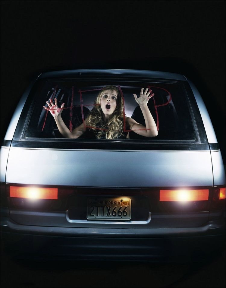 Gellar seen from the back window of a car with Help written in red on it. She is screaming with her hands against the glass in a stylized pose.