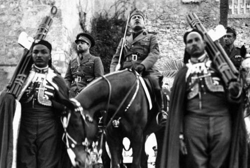 Benito Mussolini in Libya, 1939. Note he is being escorted by two men carrying fasces, an axe bundle