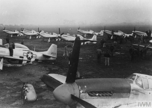 Members of the 78th Fighter Group look at the P-51D andP-51K Mustangs at RAF Duxford (December 1944)