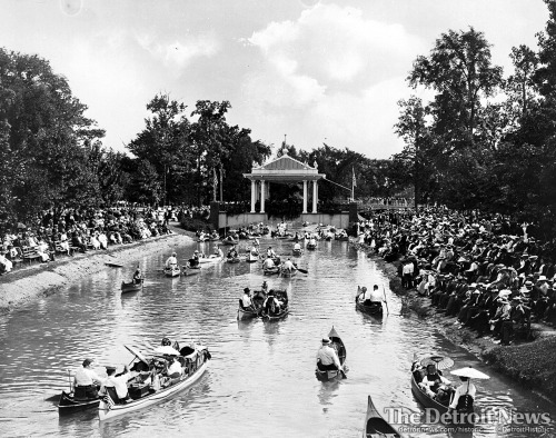 Visitors line the canal banks and ride in canoes as they listen to a concert on Belle Isle in 1902. 