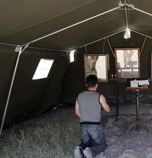 A refugee from South Ossetia prays inside of a makeshift church in a tent in Gori, Georgia, on Septe