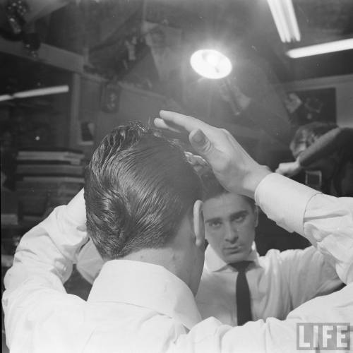 Getting the hair just right(Nina Leen, seen in the mirror. 1954)