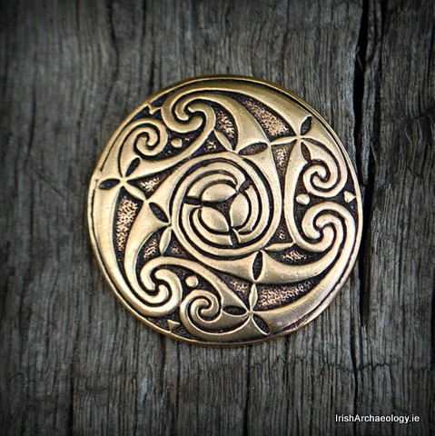 Fashioned out of bronze, this large pendant is decorated with triskele and spiral motifs which are i