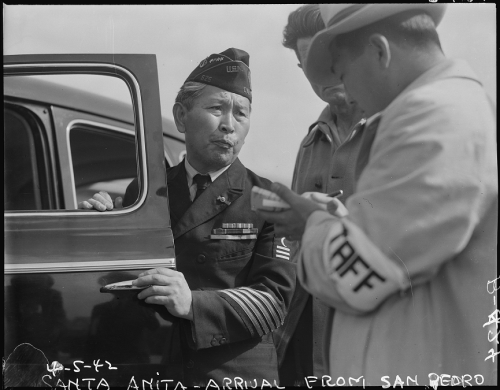 Wearing his WWI U.S. Navy uniform, a man of Japanese descent arrives at Santa Anita Assembly Center 