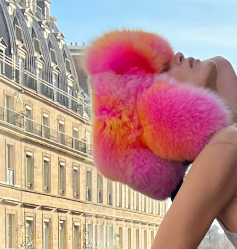 Playful Bella Hadid larks around in a pink fur hat and Louis Vuitton chain  top