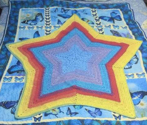 crocheted star blanket in rainbow-ish colors