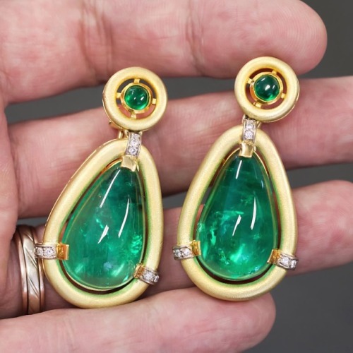 This pair of ear pendants is set with impressive 43.00 carats of luscious pear-shaped cabochon emera