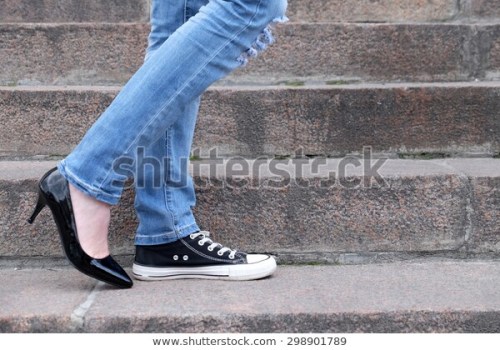 mismatched converse sneakers on legs