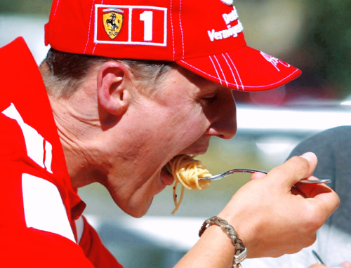 CANADA, 2004 — Michael Schumacher eats (traditionally spaghetti) with the team before the race. (Ph