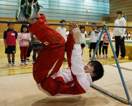 a1tumbling:  子供たちにブタの丸焼きを披露する内村航平 The caption reads, “Kohei Uchimura performs ‘roasted pig’ for the 