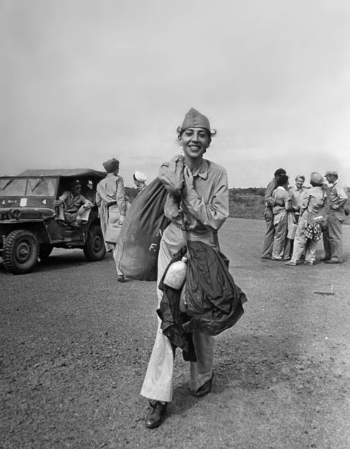 bag-of-dirt:  A U.S. Army nurse carries her gear prior to boarding a plane for transport after being liberated from a Japanese internment camp. She had been a POW for three years. Manila, National Capital Region, Luzon, Philippines. February 1945. Image