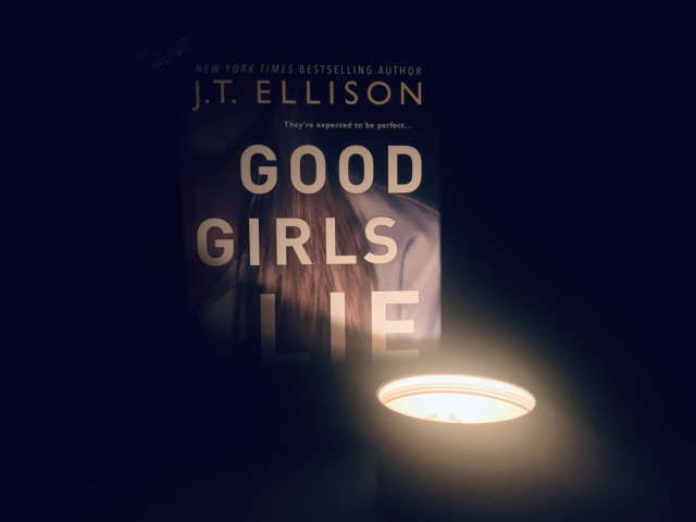 Shown is GOOD GIRLS LIE (with cover art depicting a young woman with long hair, apparently in a school uniform) in darkness, partially lit by a glowing candle. Photo by AHS.