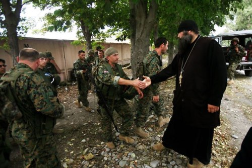 A priest greets Georgian soldiers as they rest beside the road between Tskinvali and Gori, 20 km fro