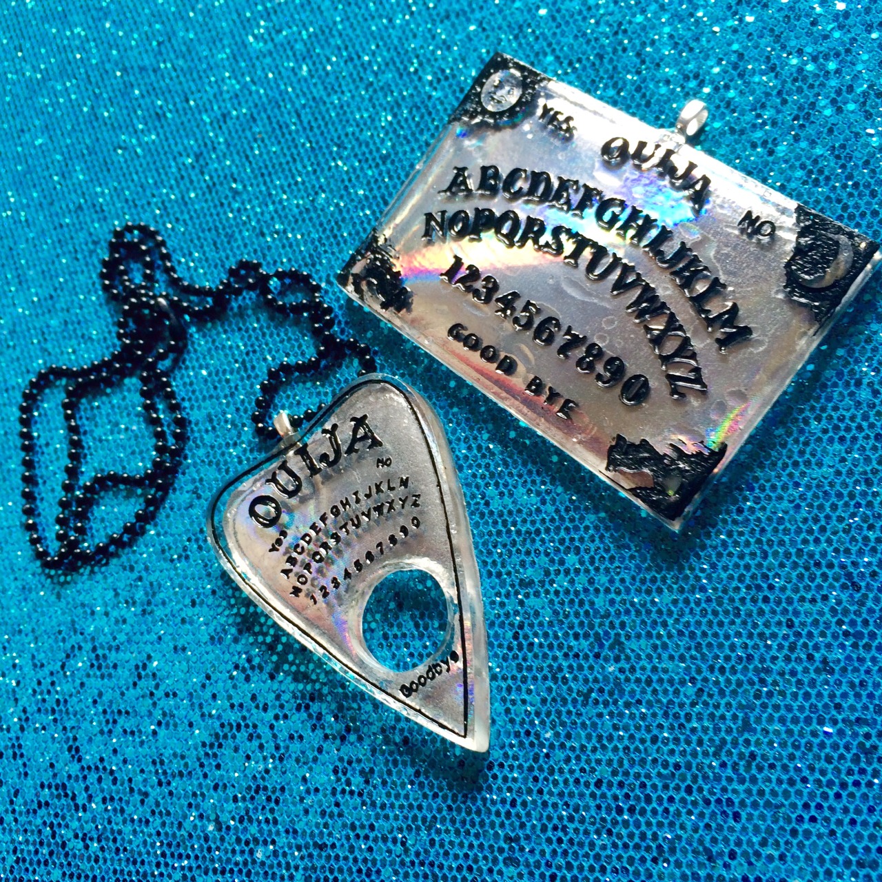 jinxandcurses:  NEW! Holographic ouija boards in planchettes in pink, purple, blue,