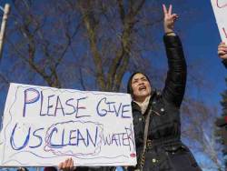 kaijuno: I’m reposting this story in it’s entirety because the situation is getting dire and no one’s helping. [Top] Gina Reynolds, a University of Michigan Flint student majoring in social work, chants “clean water is a human right,” at cars