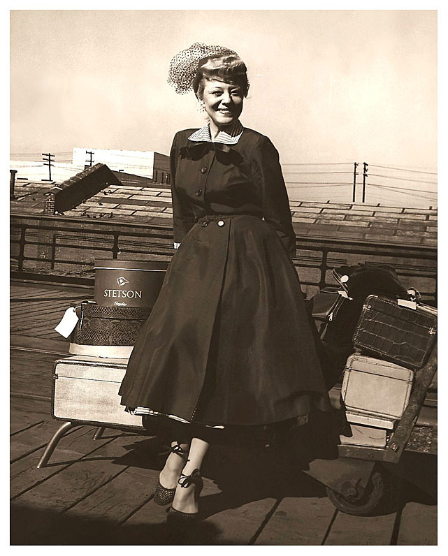 Vintage photo from 1952, shows Sally Rand waiting (with her baggage) for a train