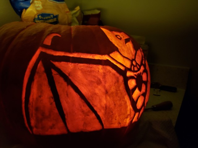 Side view of the pumpkin carving showing off the right wing, which has three bony fingers and a large hooked thumb.