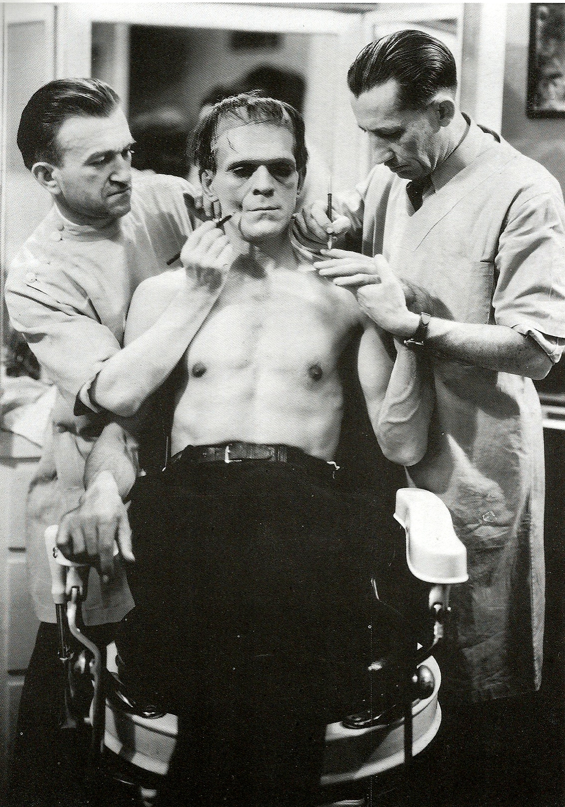 Boris Karloff undergoing make-up application during the filming of Frankenstein (1931).