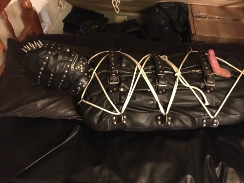 jamesbondagesx:  Gimp in full rubber, rubber hood, leather gimp hood, leather sleepsack roped up tight and milked 