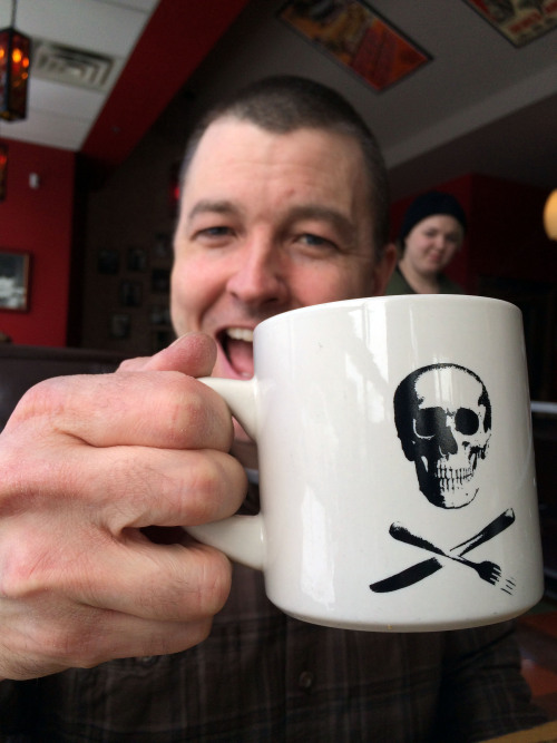 Mugshot Monday - “Bad Waitress – Skull & Cross-Silverware” coffee mug with Spyhouse Coffee
I’m on ‘Staycation’ and my wife’s school is on Spring Break, so we get to go out to lunch together! Without kids!
Love this coffee mug. Great photobomb behind...