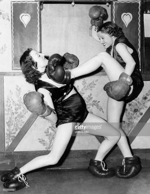 vintageeveryday:Two women boxing with boxing gloves on their hands and feet in a New York nightclub, 1938.