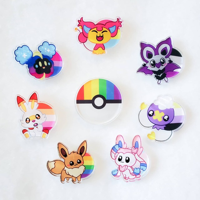 A circle of 7 pins with one pin in the middle. Going clockwise, there is a skitty pin, noibat pin, drifloon pin, sylveon pin, eevee pin, scorbunny pin, and cosmog pin. In the center is a pokeball pin.