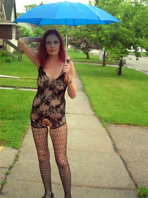 showoffmyslut:  Posing in public on a rainy day wearing her new body-stocking (and a couple indoor s