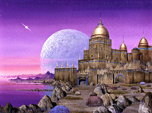 GIF 3: scenic view of a castle by a lake. the lake is on the left hand side of the frame, the castle on the right. it is built of brown stone and has several towers with golden dome roofs. the foreground is a path lined with rocks that is leading up to the castle gate. the sky is pink and purple and a large full moon has half risen behind the castle.