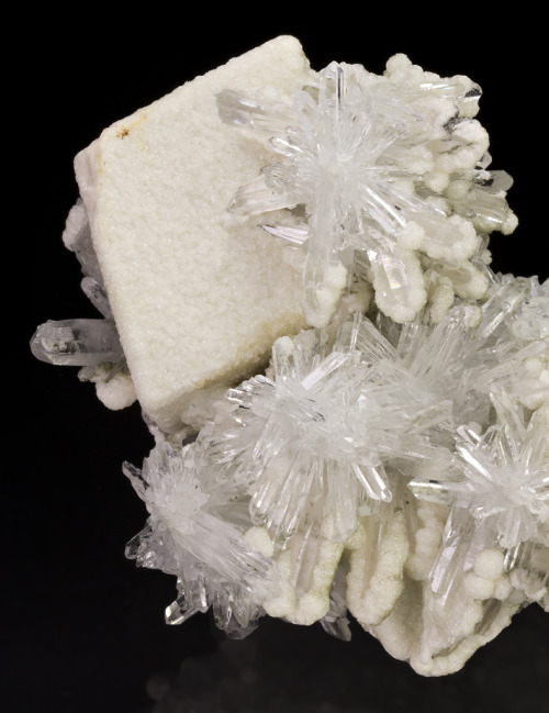 mineralists: Sparkling white rhombohedral Calcite crystal set on a matrix of crystallized Quartz and