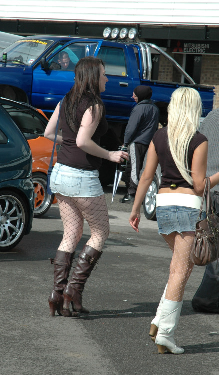 Sexy woman in short denim skirt and black fishnet pantyhose caught in the street. Woman in pantyhose