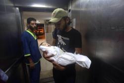 redphilistine:  nowinexile:  The entire family of this months old baby was murdered by an Israeli air strike on their home. He was left wounded until he died today. With no family members alive to bury him, this young man volunteered to do it. #Gaza 