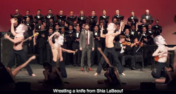 kitsunecoffee:  afictionate:  schmoyoho:  In which a children’s choir, grown-up choir, orchestra, dancing paper-mache-head Shia LaBeoufs, and aerialists perform a song about Shia LaBeouf’s gruesome cannibalistic nature TO SHIA LABEOUF. Thank goodness