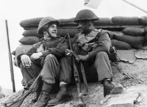 Two men of the 1st Battalion, Black Watch, rest and smokebefore moving off on patrol after heaving f