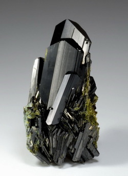 fuckyeahcrystals:  Epidote, Ca2Al2(Fe3+;Al)(SiO4)(Si2O7)O(OH). The anisotropy, or directional asymmetry, of epidote causes the stone to appear different colors from different directions. The crystal structure bends light differently depending on the