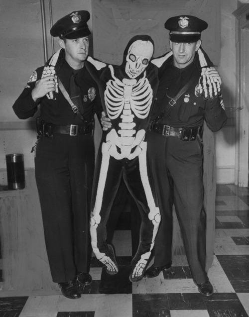 imagesofthepast:  Cops arresting a drunk dude in a skeleton costume 1950 Credit to: u/onepersononeidea