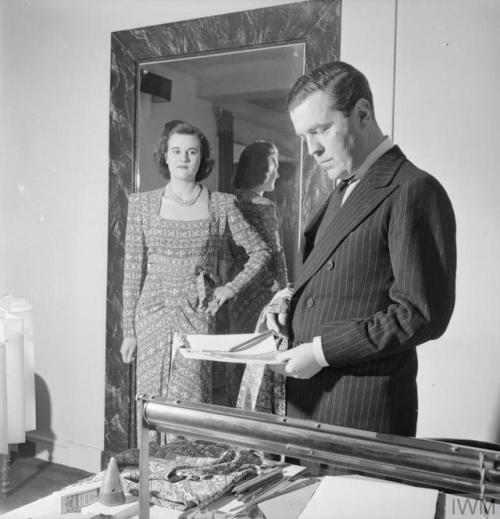 Fashion designer Norman Hartnell in his London office (1944),comparing his original sketch & fab