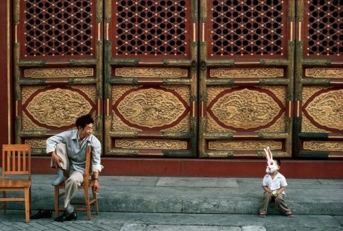 ouilavie:Thomas Hoepker. 1984. A guard and child in Bugs Bunny mask in the Forbidden City.