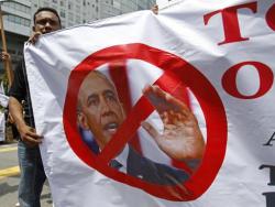 A Muslim Protester Holds A Banner Featuring A Photo Of U.s. President Barack Obama