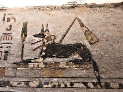 Recumbent Anubis The black jackal Anubis reclines on a shrine, a sash tied around his neck and a gol