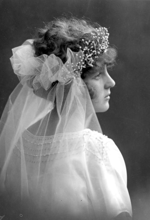 Porträtt av brud i brudklänning, slöja och hårdekoration. 1935-37