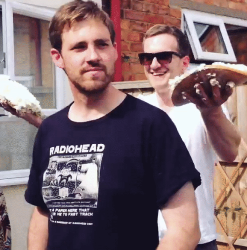 Tattooed guy gives his mate a pie in the face