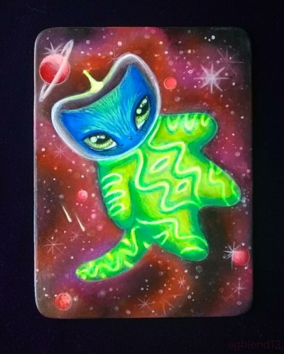 blue cartoonish cats with large almond shaped eyes wears a green spacesuit with glowing tube piping in designs over the suit and tail. their bubble helmet has a glowing antenna in the middle.