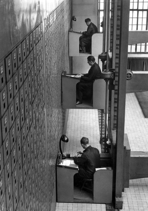 hauntedbystorytelling:  Electric elevator desks in Prague, 1937 / unknown photographer  Though it lo