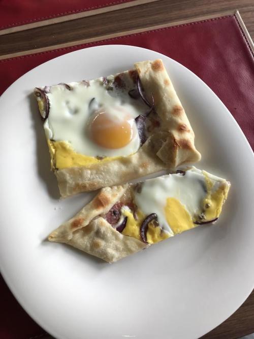 [Homemade] Flammkuchen with cheese crust, onions, fresh salami and a cracked egg.
