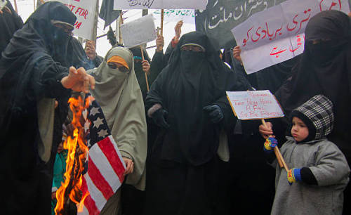 Members of the women-only group Dukhtaran-e-Millat (Daughters of Faith) burn an U.S. flag during dem