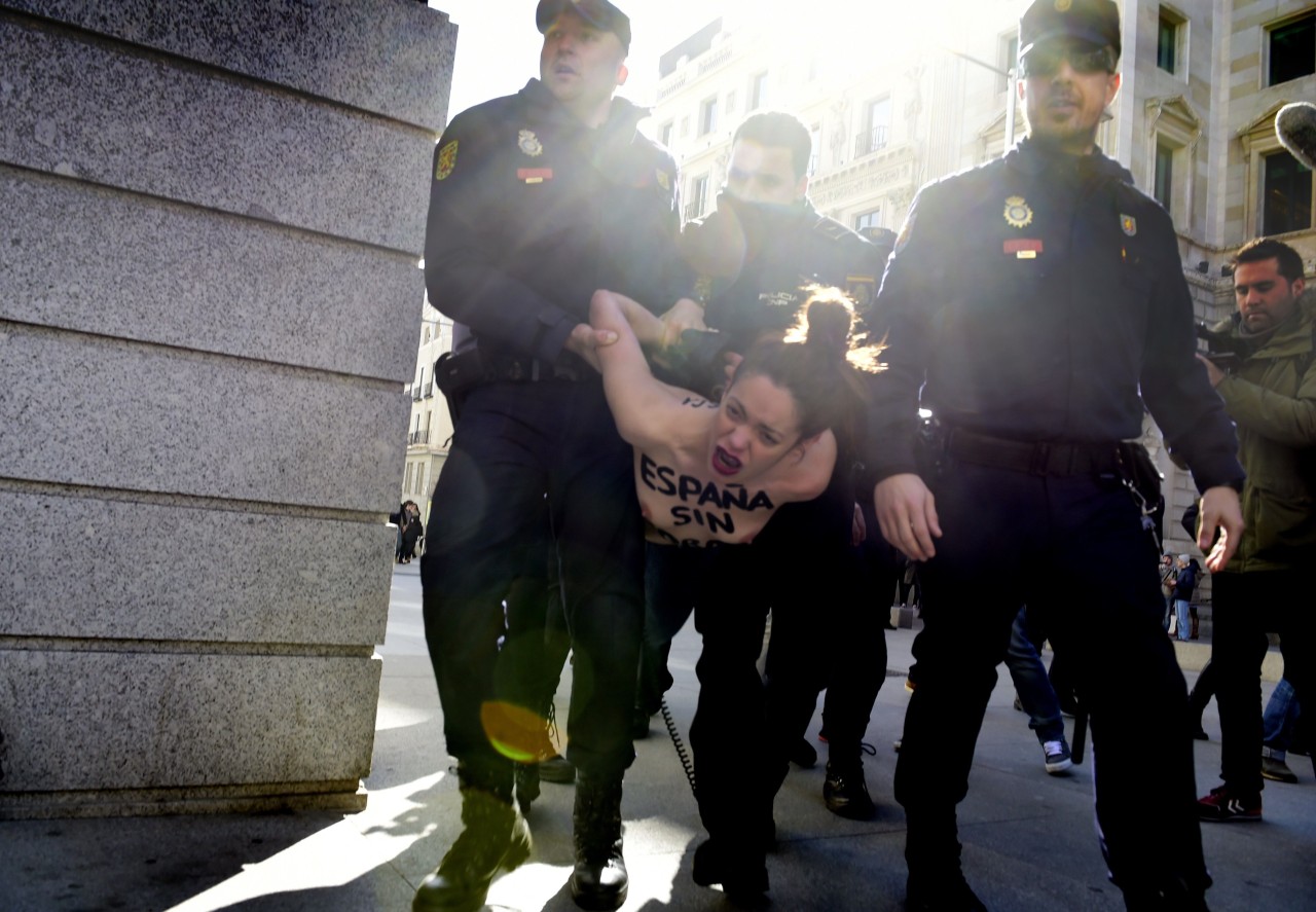 ESPAÑA. Dos activistas de Femen protestan frente al Congreso contra la ‘ley mordaza’al grito de “Protestar no es ilegal” y con los lemas “Femen for freedom” y “España sin mordaza” escritos en el torso y en la espalda desnudos. (AFP)