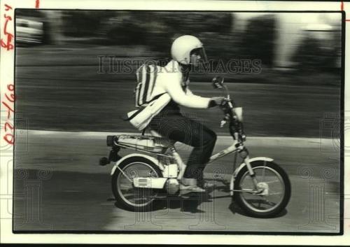 Thursday, May 1, 1980 – Getting there cheaply: A young womanrides down Wakeforest Street astride a m